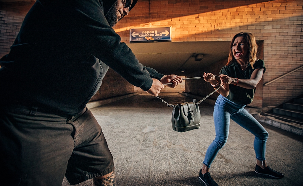 Frau versucht Ihre Handtasche zu schützen